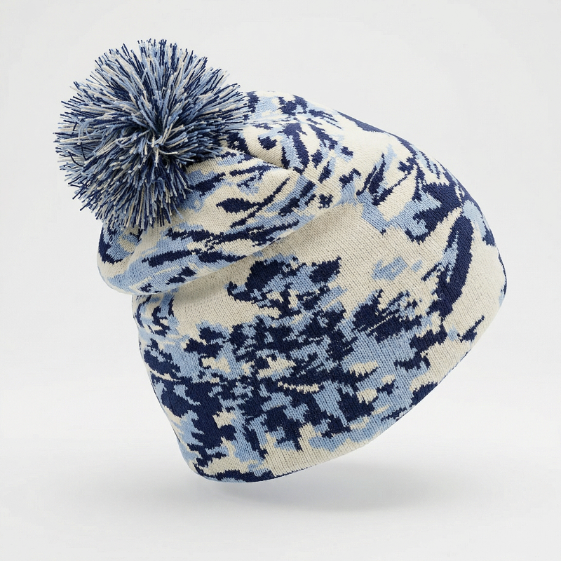 Knitted beanie with blue and white pattern and pom-pom on a light gray background