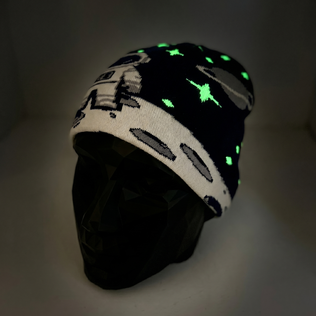Glowing beanie with space-themed design on a dark background