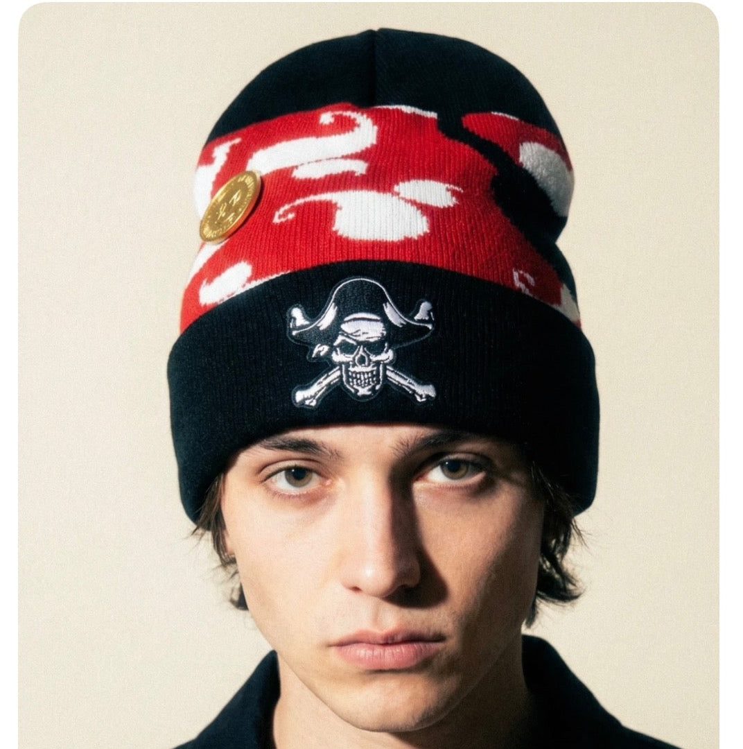 Person wearing a red and black beanie with a skull design on a beige background