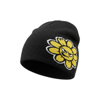 Black beanie with a yellow sunflower design on a white background
