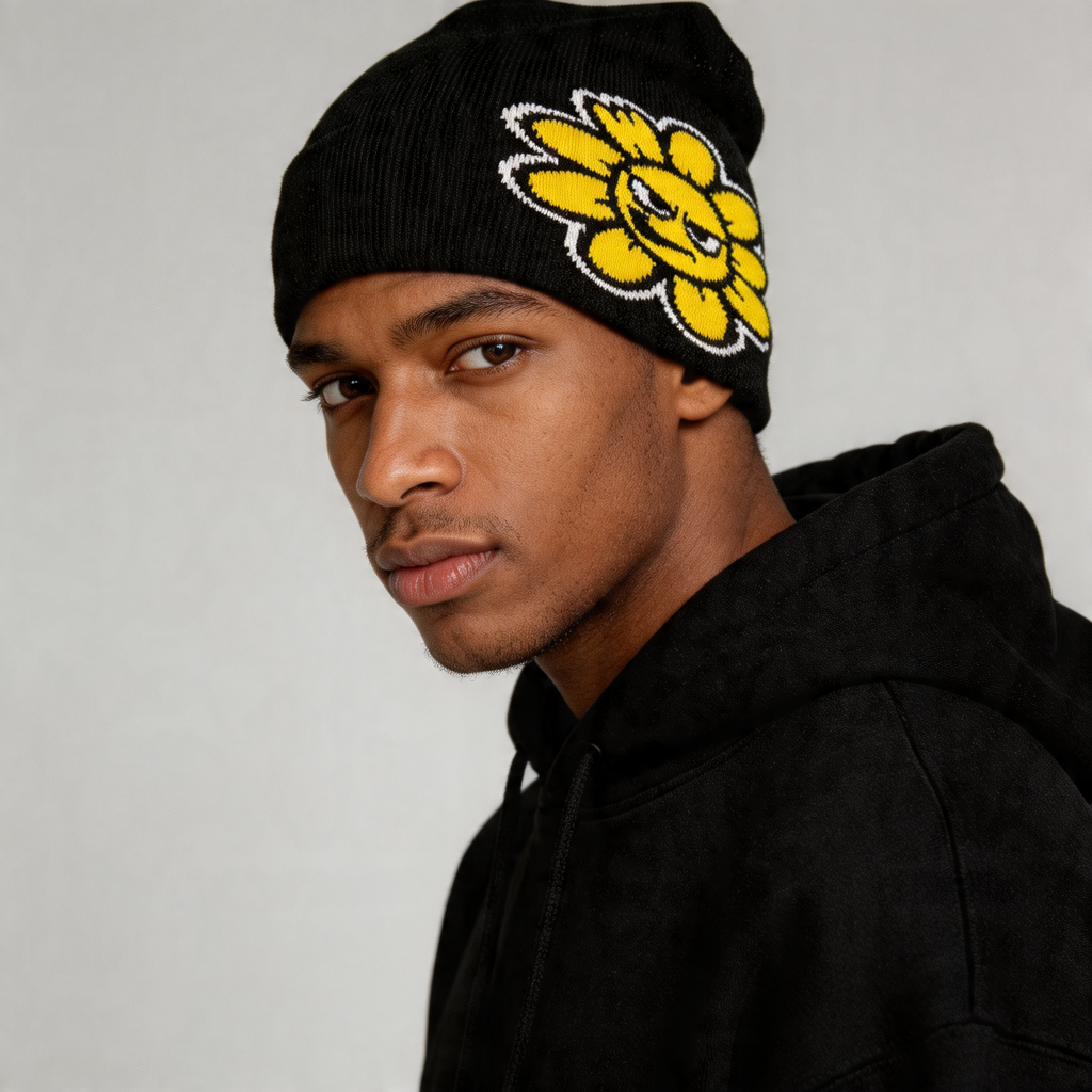 Person wearing a black beanie with a yellow flower design on a gray background