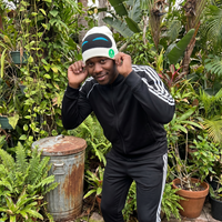 Person wearing a black tracksuit with white stripes in a garden setting