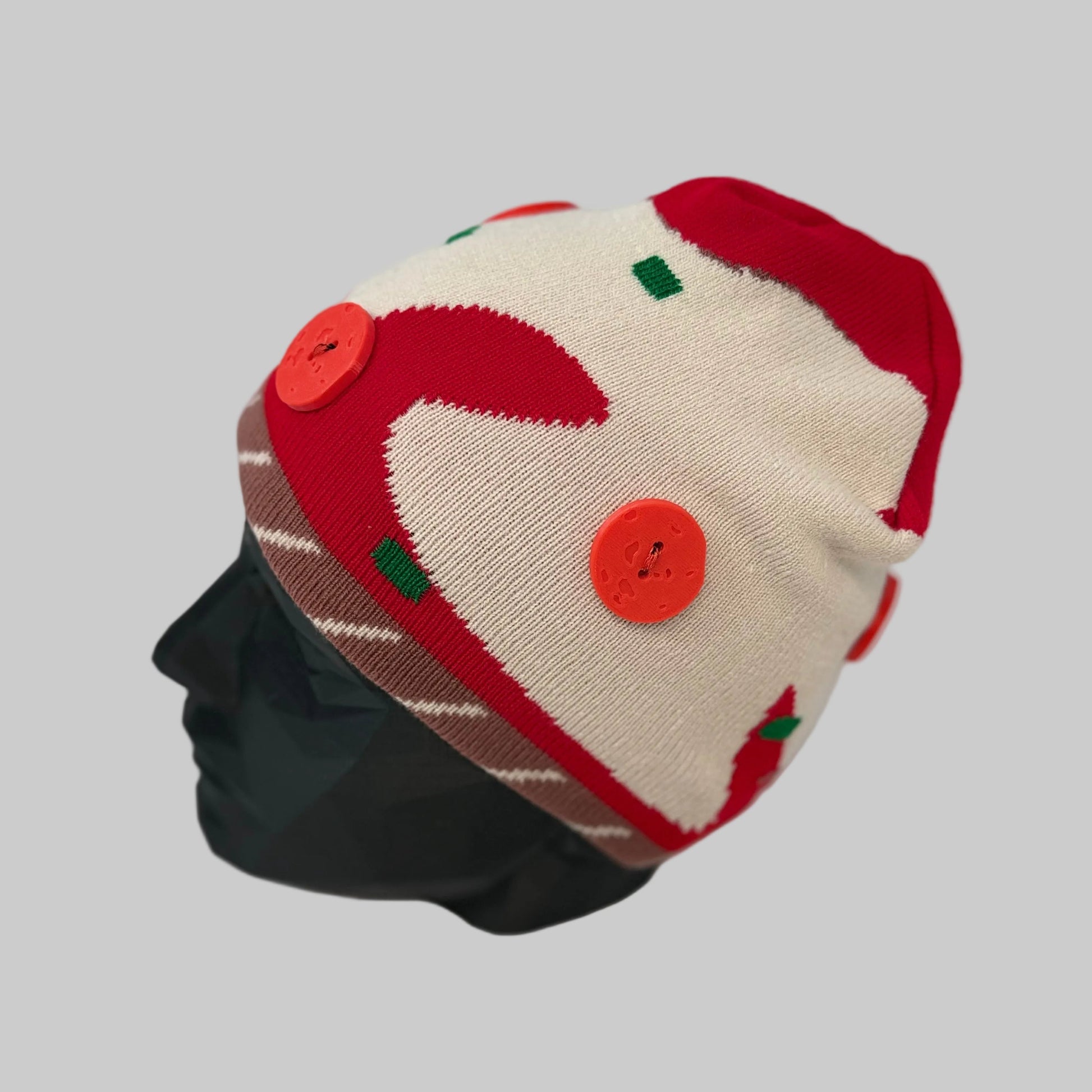 Red and white patterned beanie on a mannequin head against a white background