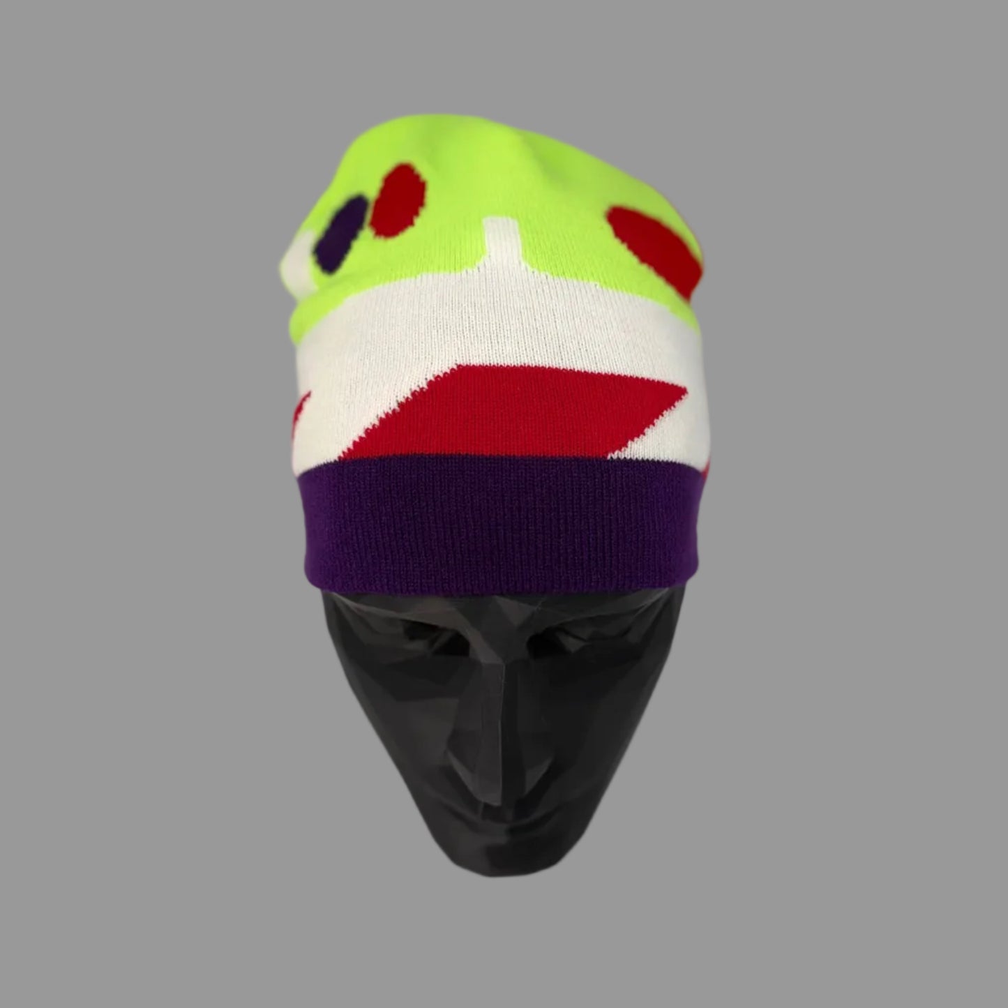 Colorful sock with a face design on a mannequin head against a white background