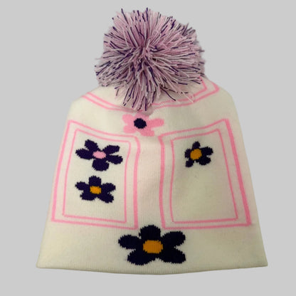 White knit beanie with purple flowers and a pink border on a white background