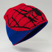 Red and blue knitted beanie with spider web pattern on a mannequin head against a white background