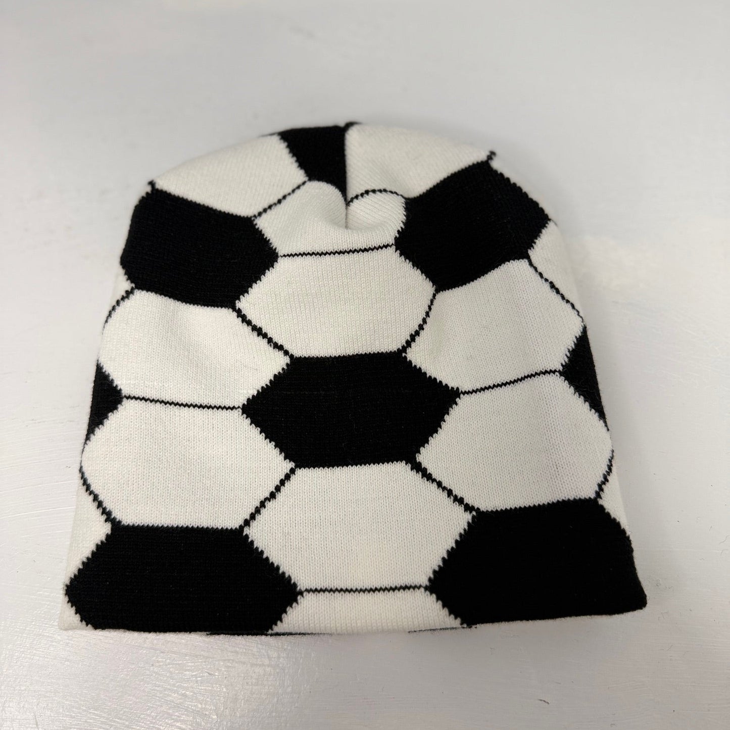 Black and white checkered beanie on a light gray background