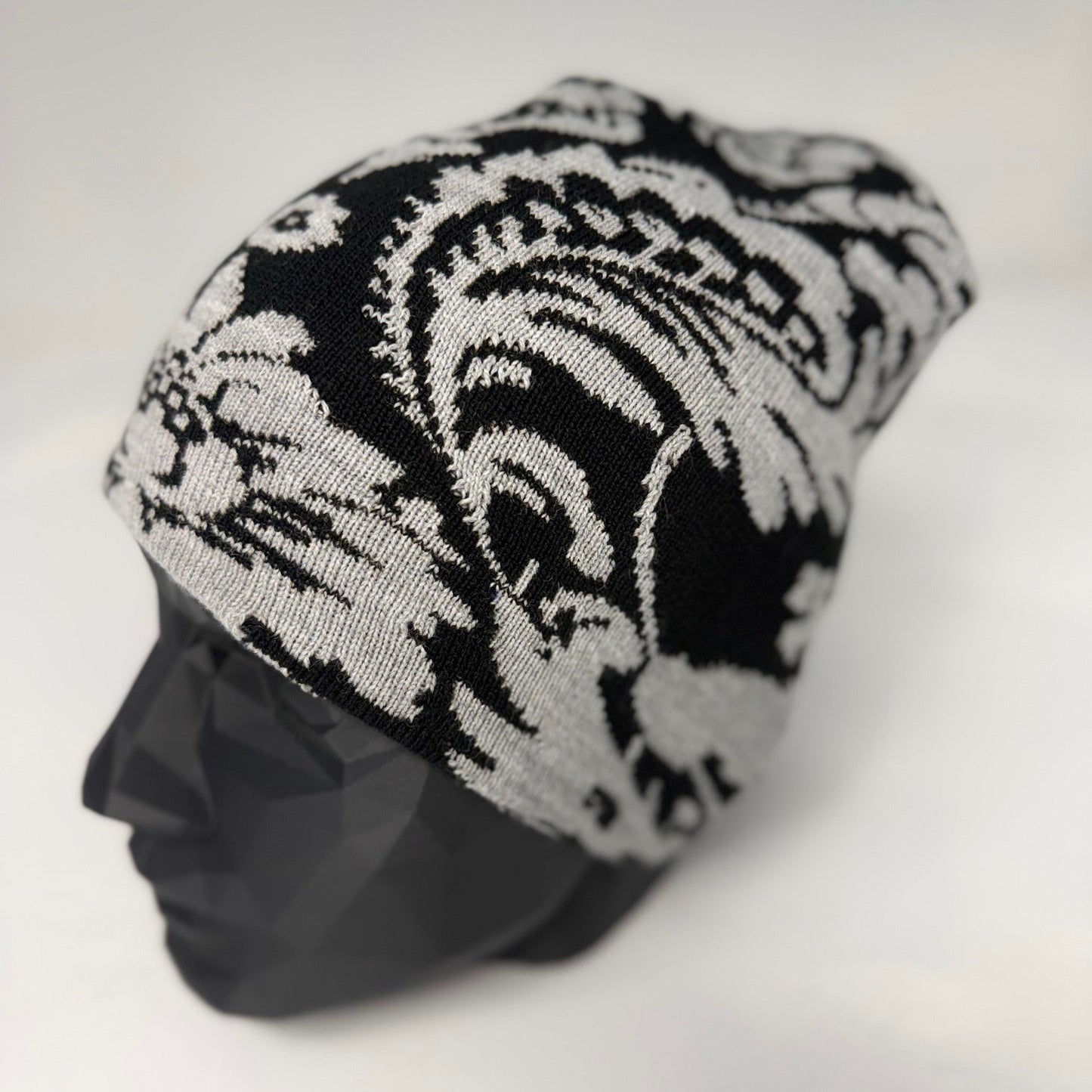 Black and white patterned beanie on a mannequin head against a white background