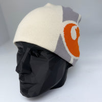 Color-blocked beanie with a large orange number '0' on a mannequin head against a white background