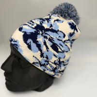 Knitted beanie with blue floral pattern on a mannequin head against a gray background