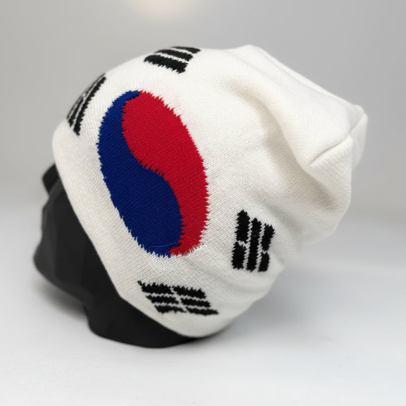White beanie with a red and blue emblem on a gray background