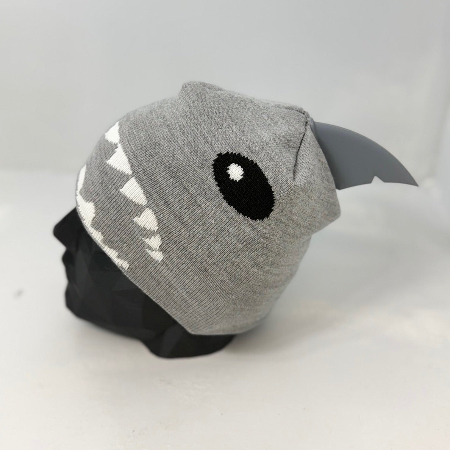 Gray shark-themed beanie on a mannequin head against a white background