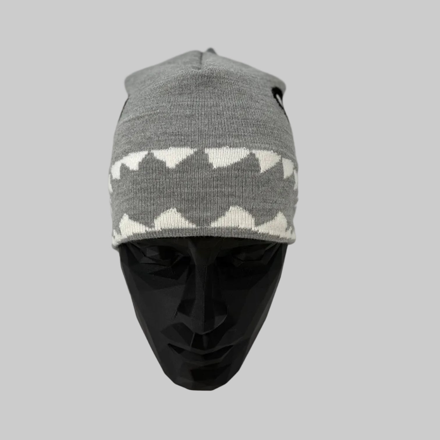Gray and white patterned beanie on a mannequin head against a white background