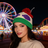 Woman wearing a colorful beanie with a ferris wheel and roller coaster in the background at night.