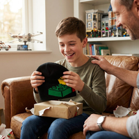 Boy receiving a gift from an adult on a couch, with toys in the background