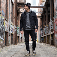 Man standing in an alleyway with graffiti on the walls