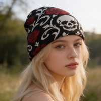 Woman wearing a black beanie with skull and rose patterns in a natural setting