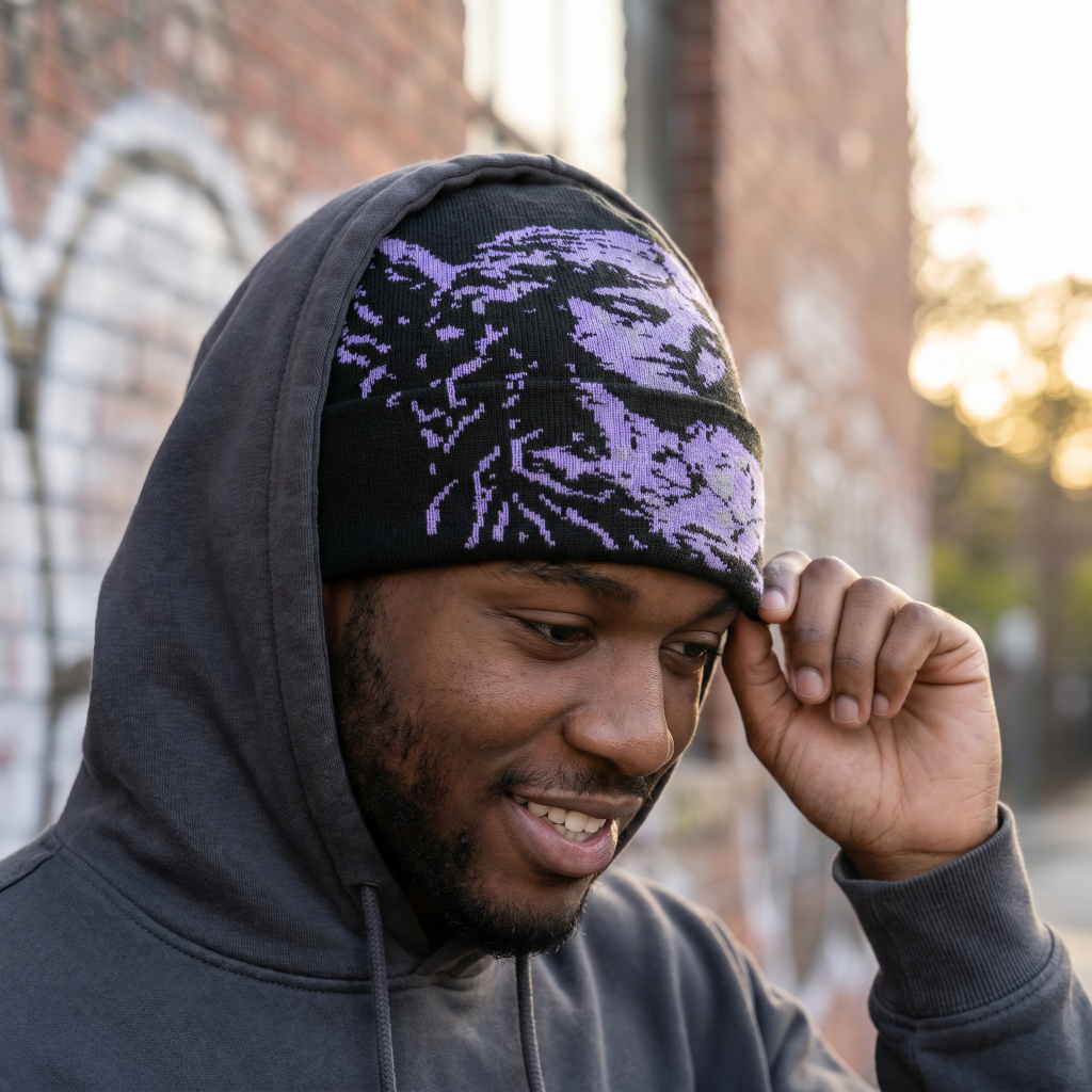 Person wearing a dark hoodie and a patterned beanie outdoors