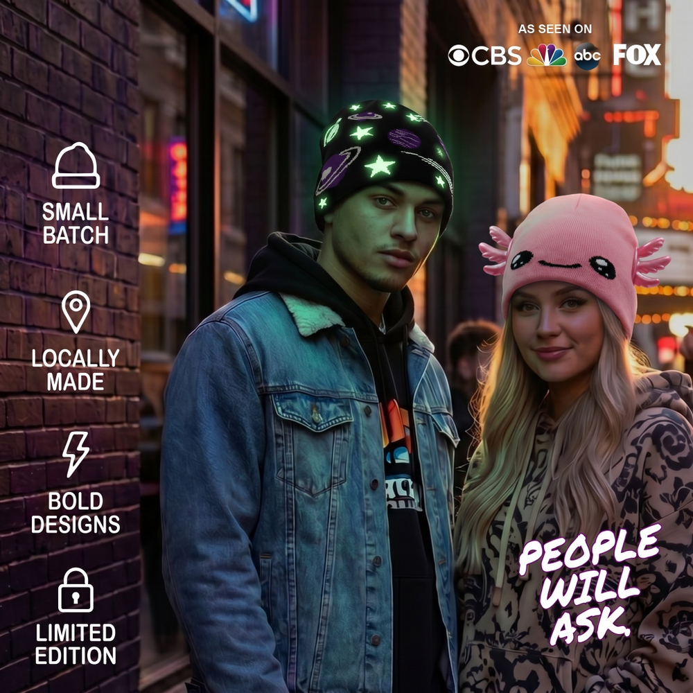 Two people wearing hats with neon lights on a city street at night.