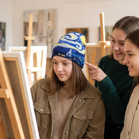 Girl painting while wearing starry night beanie 