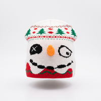 Knitted snowman hat with a white face, black eyes, orange nose, and red scarf on a white background.