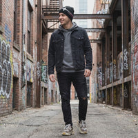 man wearing shooting star beanie in alley