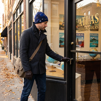 Man wearing airline route beanie walking into store 