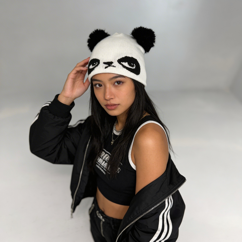 Person wearing a panda-themed beanie against a plain background
